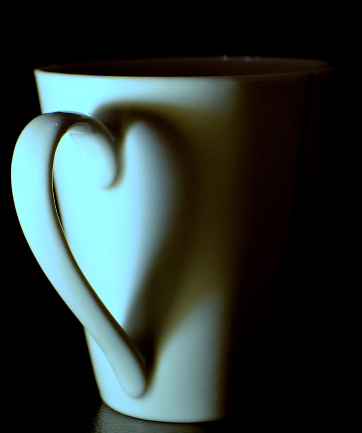 white ceramic teacup on black surface