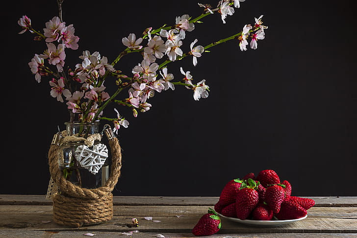 strawberries on plate beside pink flowers