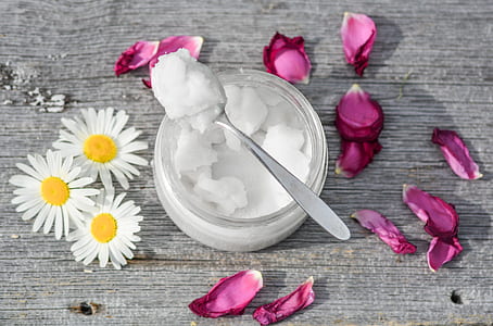 photo of stainless steel spoon with white substance in clear glass jars with petaled flowers