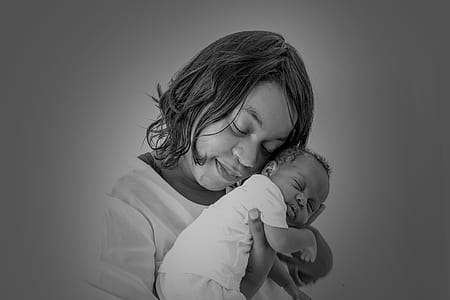 grayscale photo of woman carrying baby