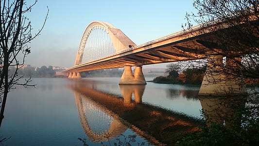 Grey Concrete Bridge Above Water Under Blue Sky