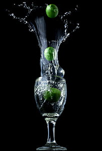 clear wine glass with three green limes
