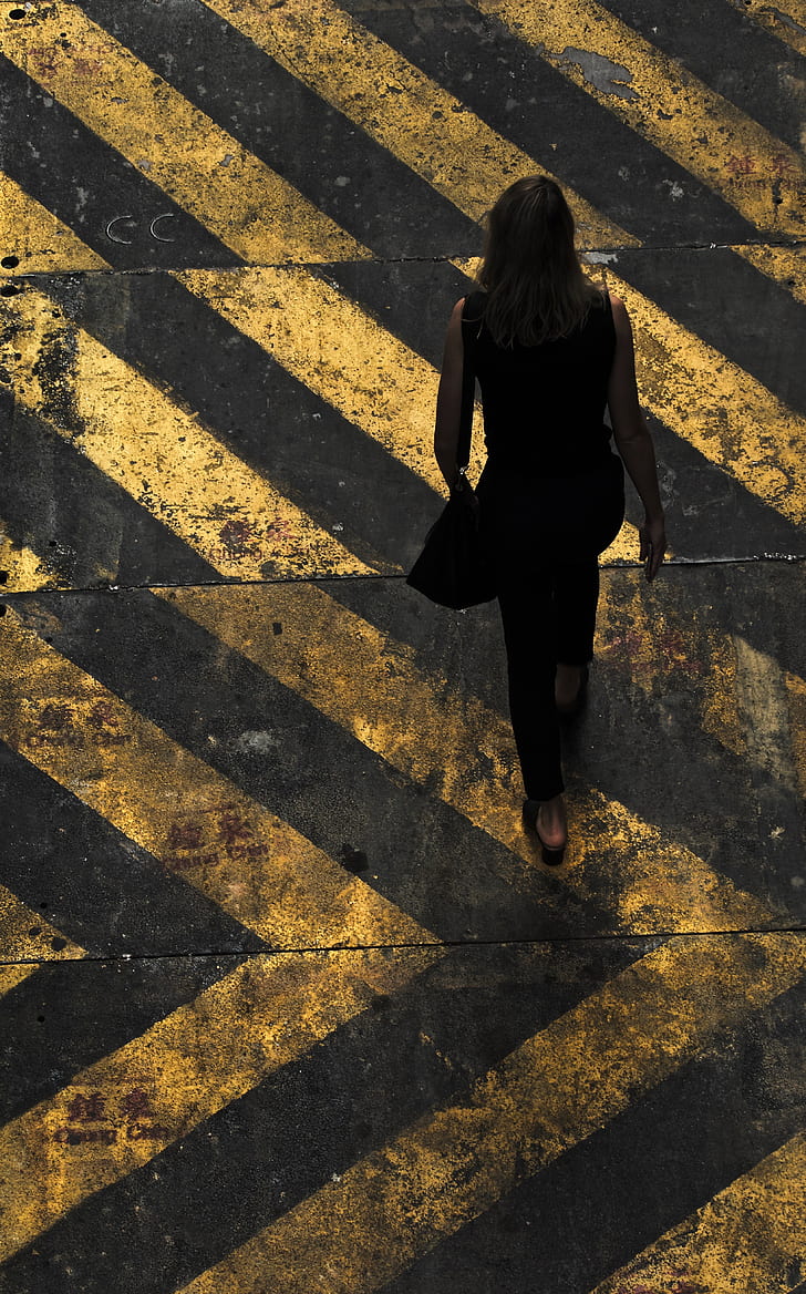 aerial view photography of woman walking on pedestrian lane