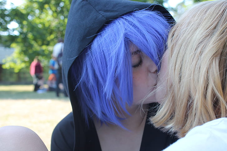 two female cosplayer kissing wearing black hoodie