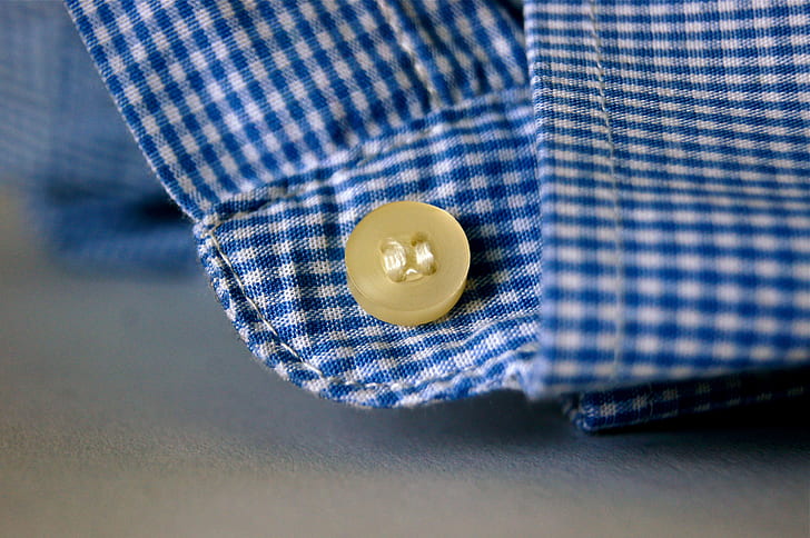 brown button on blue and white plaid textile photo