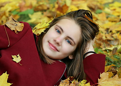woman laying in yellow leaf covered field
