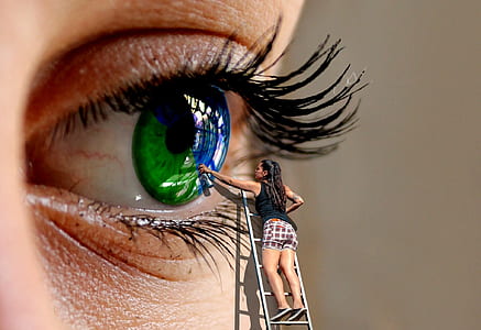 macro shot of woman painting the green eye