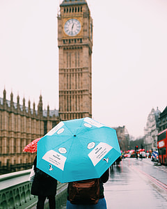 person with cyan umbrella near the Big Ben in London selective focal photo