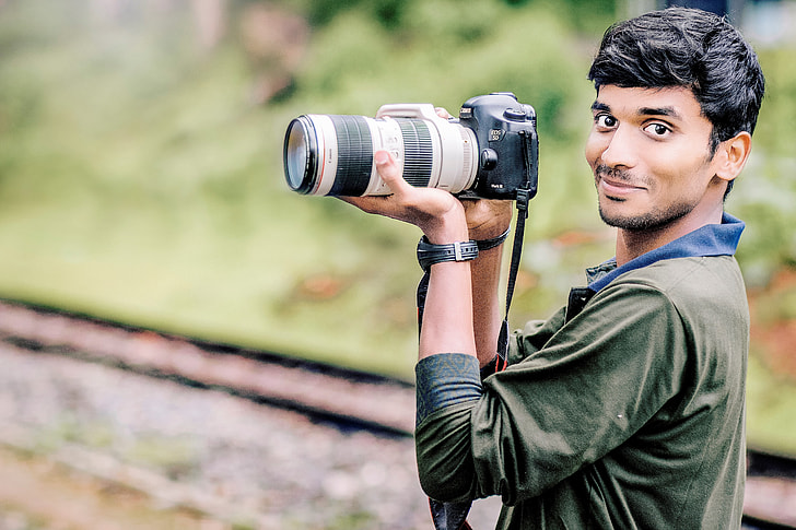 Man photographer with a DSLR camera in her hands posing - stock photo  3190148 | Crushpixel