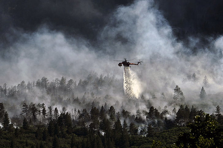 helicopter burning above trees