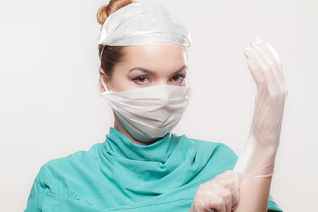 woman wearing teal top and latex gloves