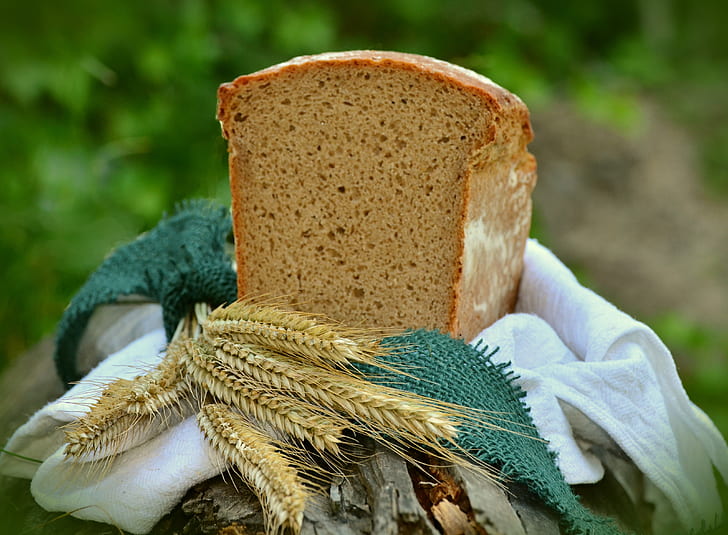 sliced banana bread on top of white textile with grains