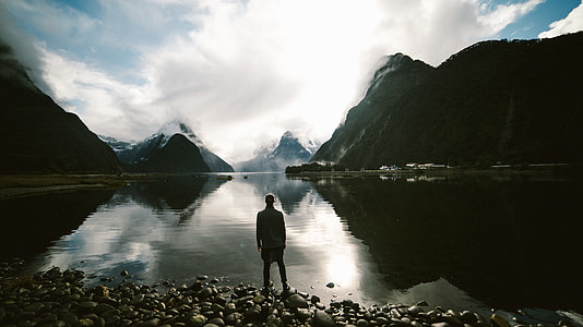 silhouette of person in front of body of water during daytime