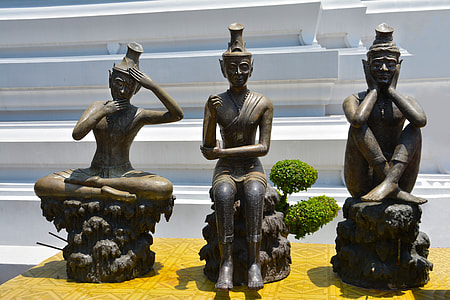 three wise buddha figurines on desk