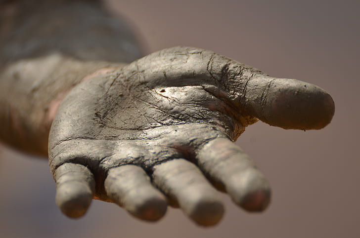 left human palm covered with soil