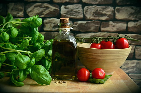 cherry tomatoes, green spinach and olive oil sitting on the table