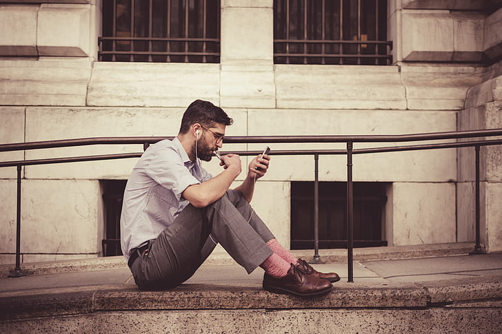 man listening to music while looking at phone