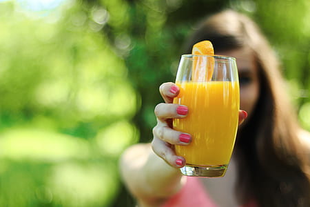 woman holding glass of juice