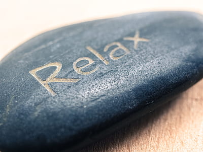 closeup photo of blue stone with relax text engraved