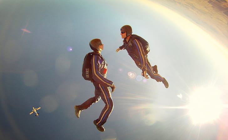 two person facing each other while skydiving