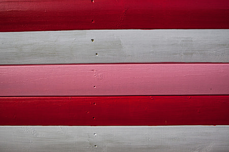 Close-up shot of red, white and pink-coloured wood panels. Image captured in Whitstable, Kent, England