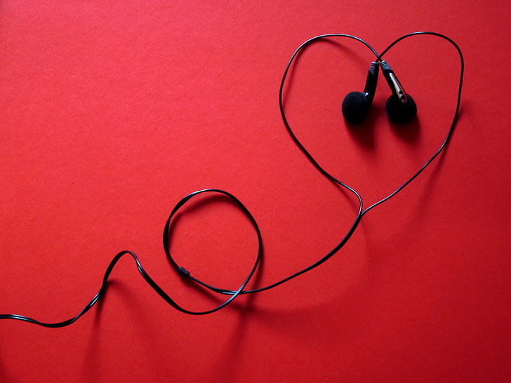 black corded earphones on red surface