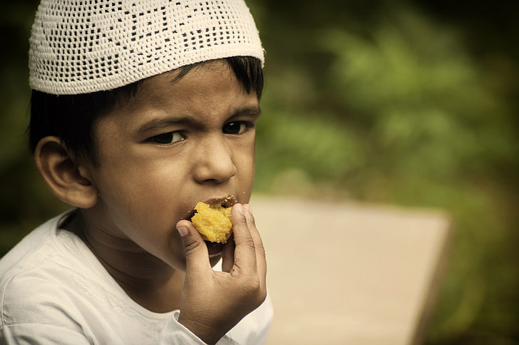 focal photography of boy eating food