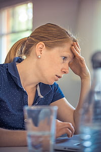 woman wearing blue polo shirt using laptop