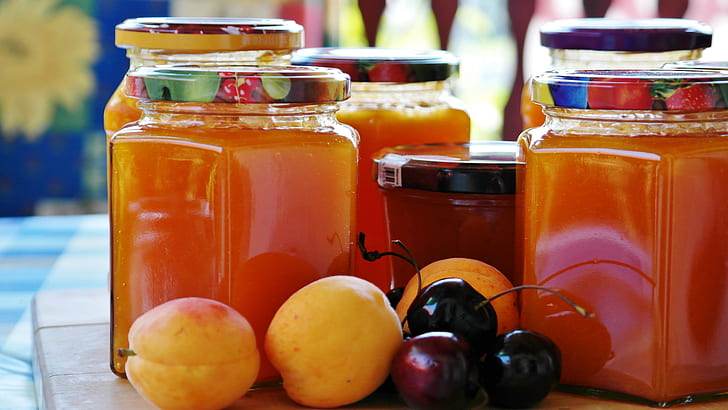 assorted fruits beside five glass mason jars