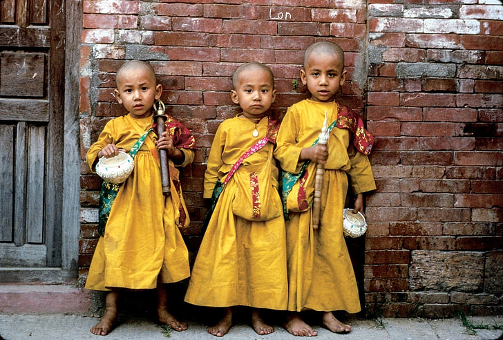 three boys wearing yellow thobes