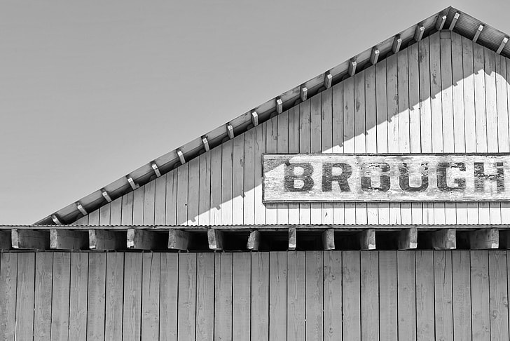 grayscale photo of a wooden signage