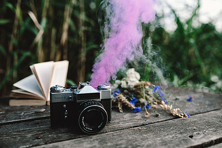 Colorful smoke bomb, book and vintage camera