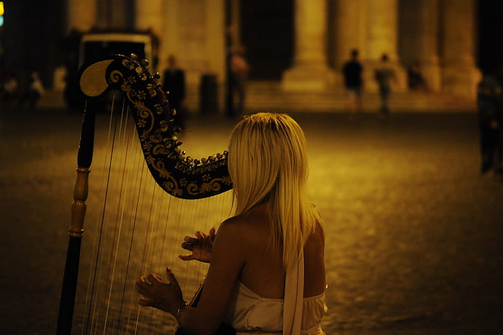 woman in white dress playing harp