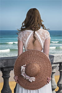 woman holding round beach hat