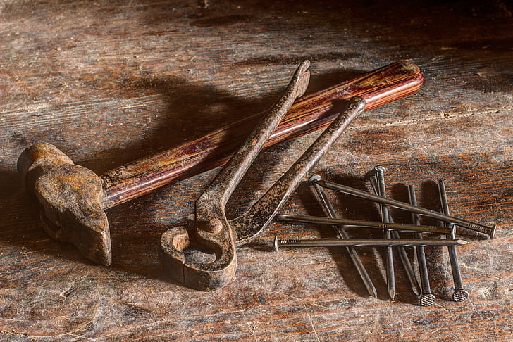 brown hammer, black tong, and gray nails
