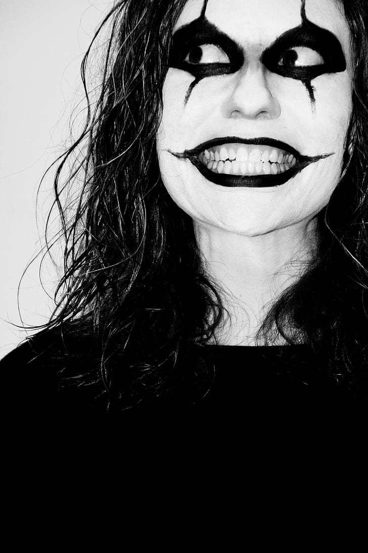 greyscale photo of woman with clown face paint