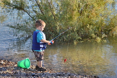 boy fishing in body of water