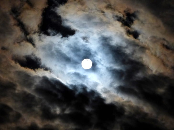 low-angle photography of moon near white clouds and blue sky
