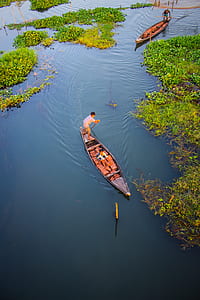 Two Person Riding Black Wooden Boats