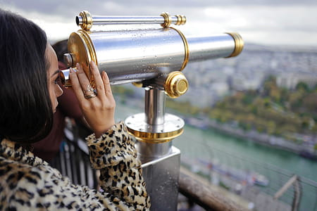 woman taking a peek on coin operated telescope