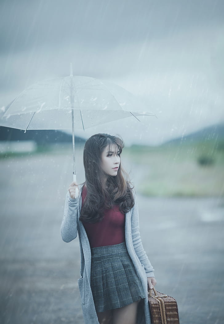 woman wearing gray cardigan holding white handle umbrella