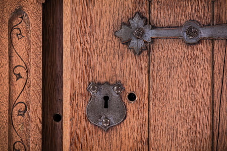 black steel keyhole on brown wooden door