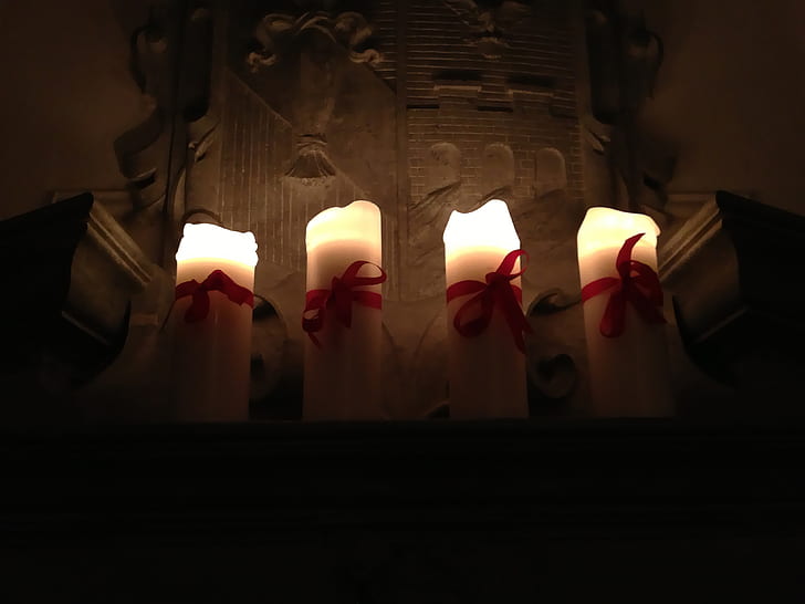 four lighted white pillar candles