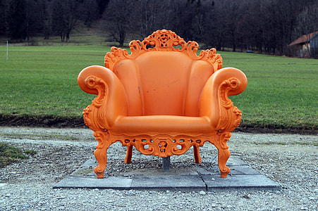orange padded armchair with wooden frame