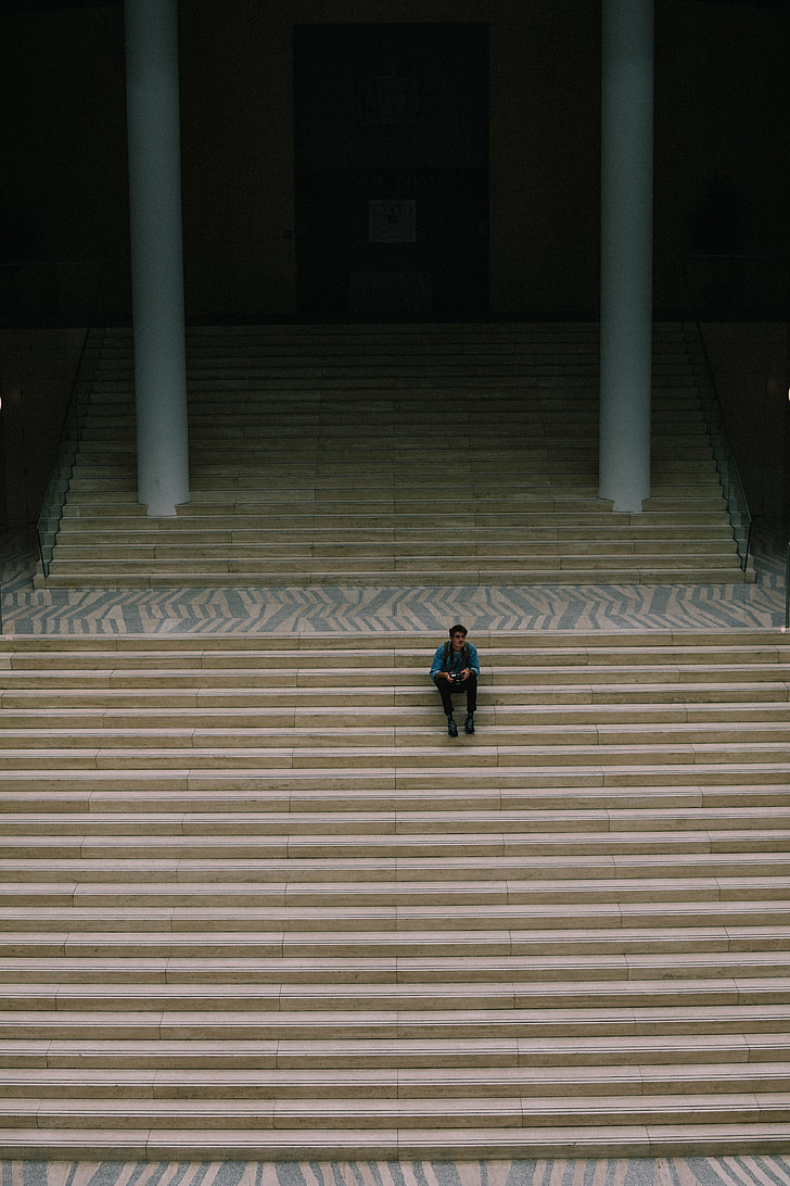 man sitting on beige stair