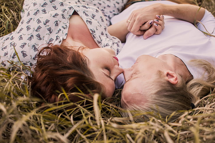 two woman lying on green grasses