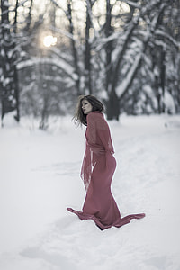 photo of woman in purple dress walking during winter