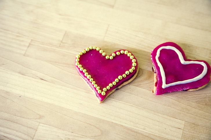 two heart-shape pink textiles on brown wooden floor