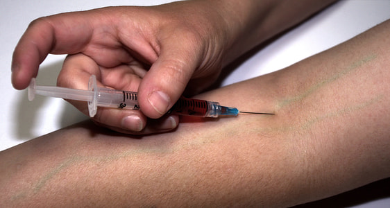 person injecting himself with a syringe