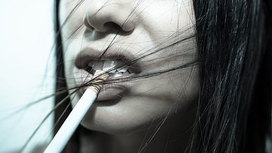 woman biting cigarette stick